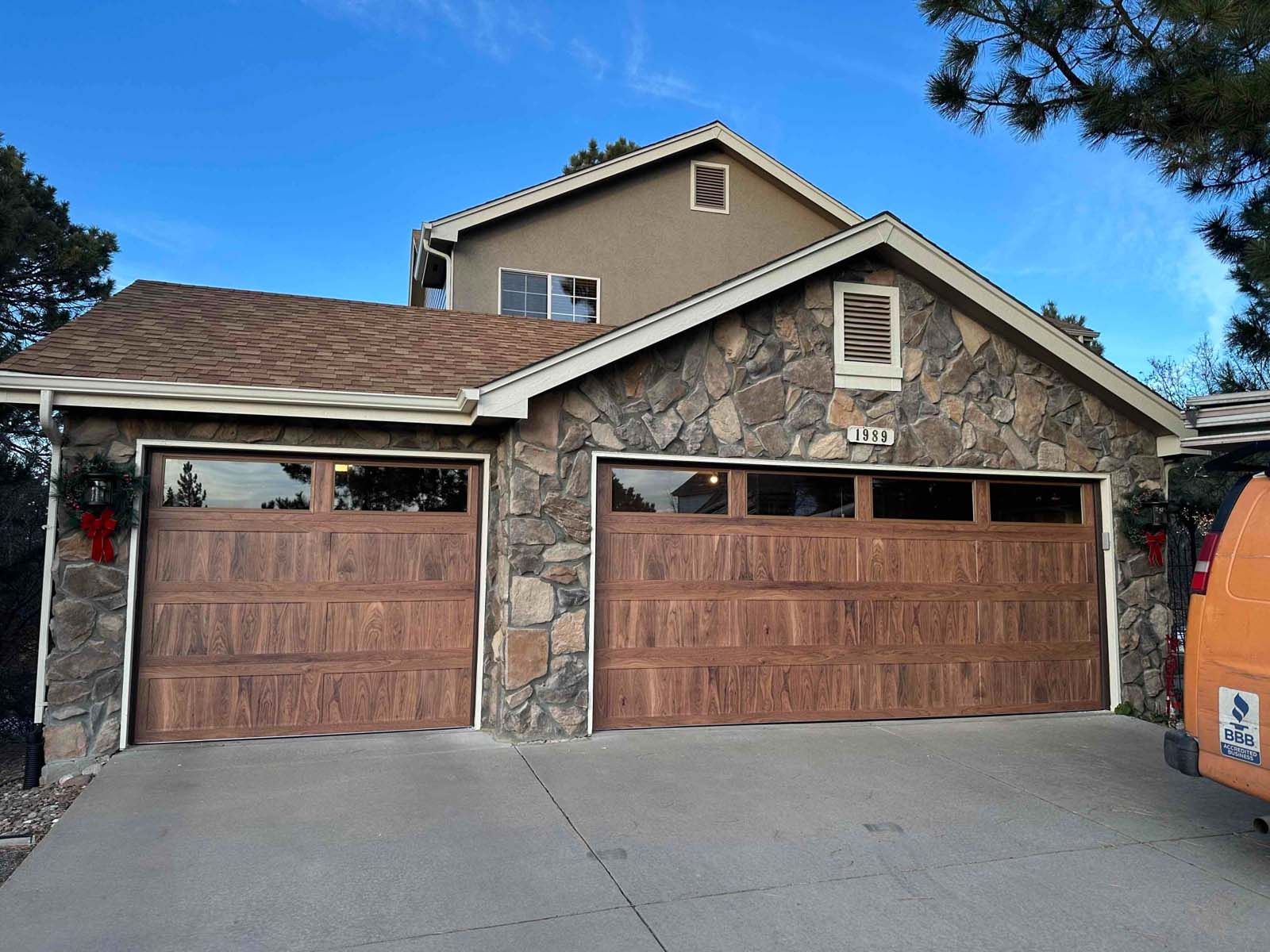 A house with two garage doors and a van parked in front of it