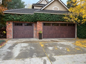 A large house with two garage doors and a driveway.