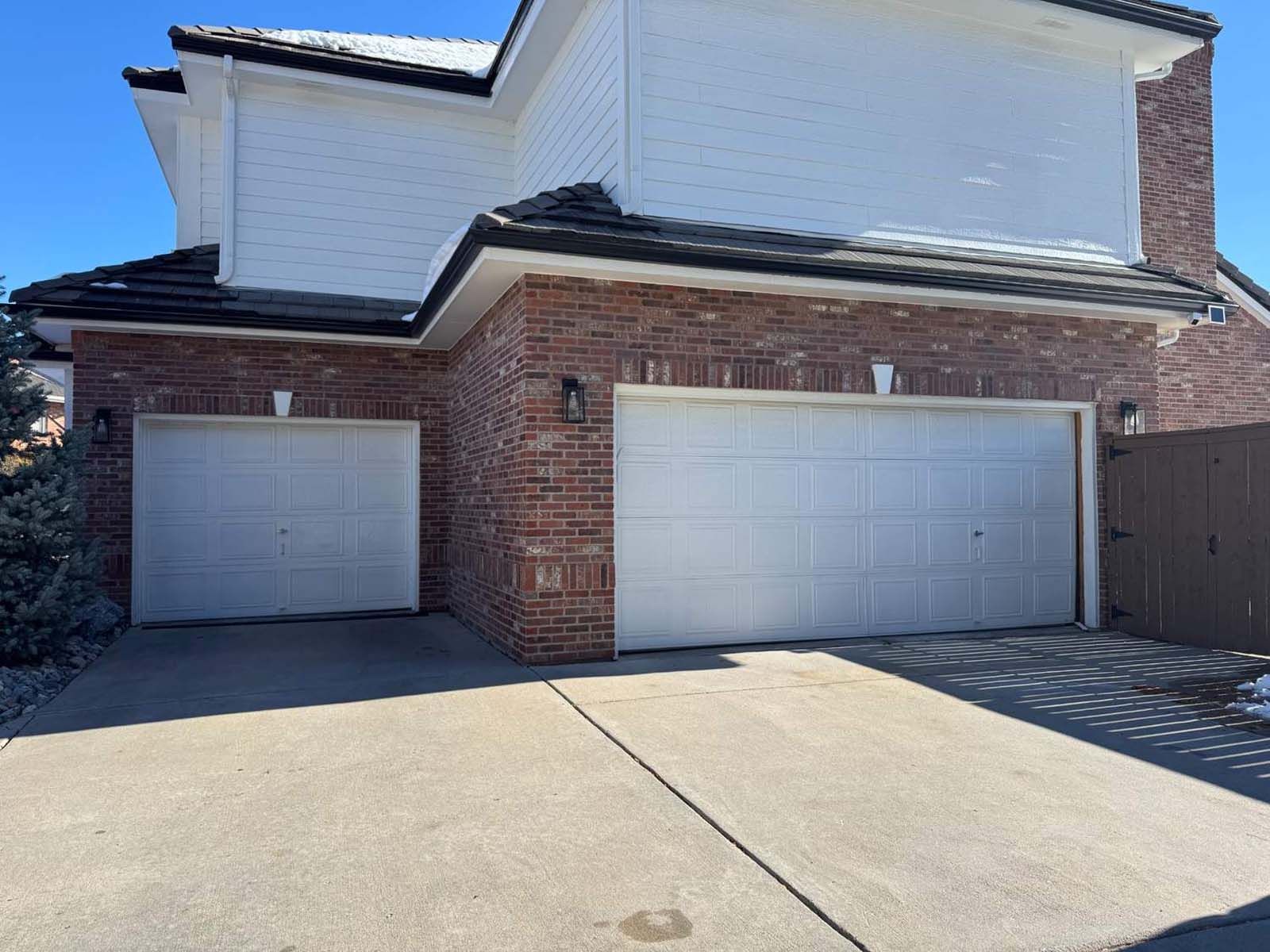 A large brick house with two white garage doors