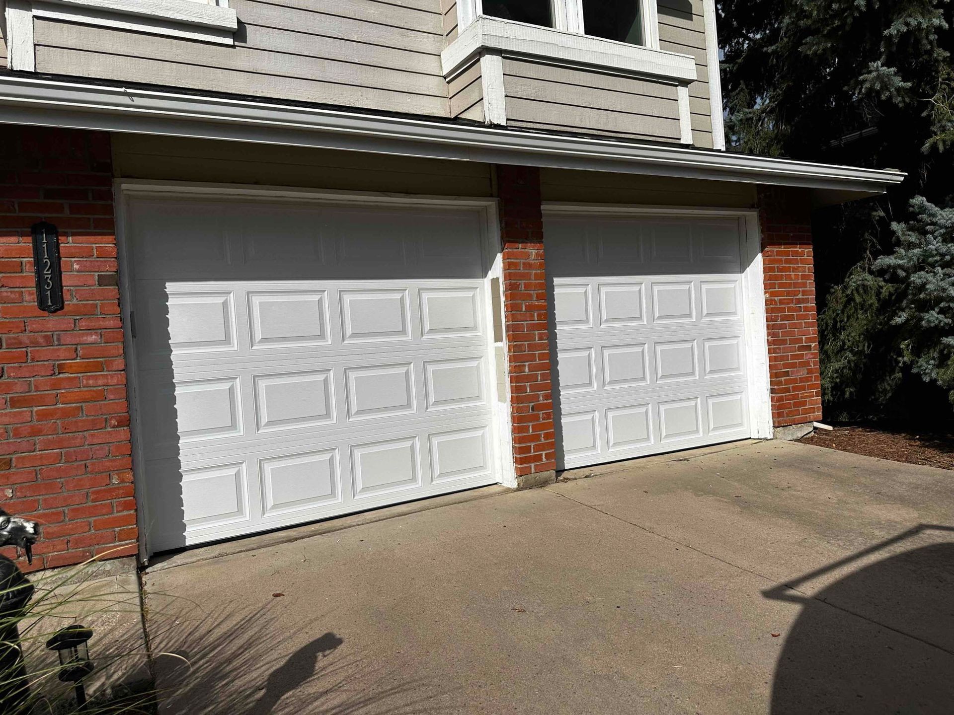 Double and single garage doors in white, short raised panel installed in Littleton, CO