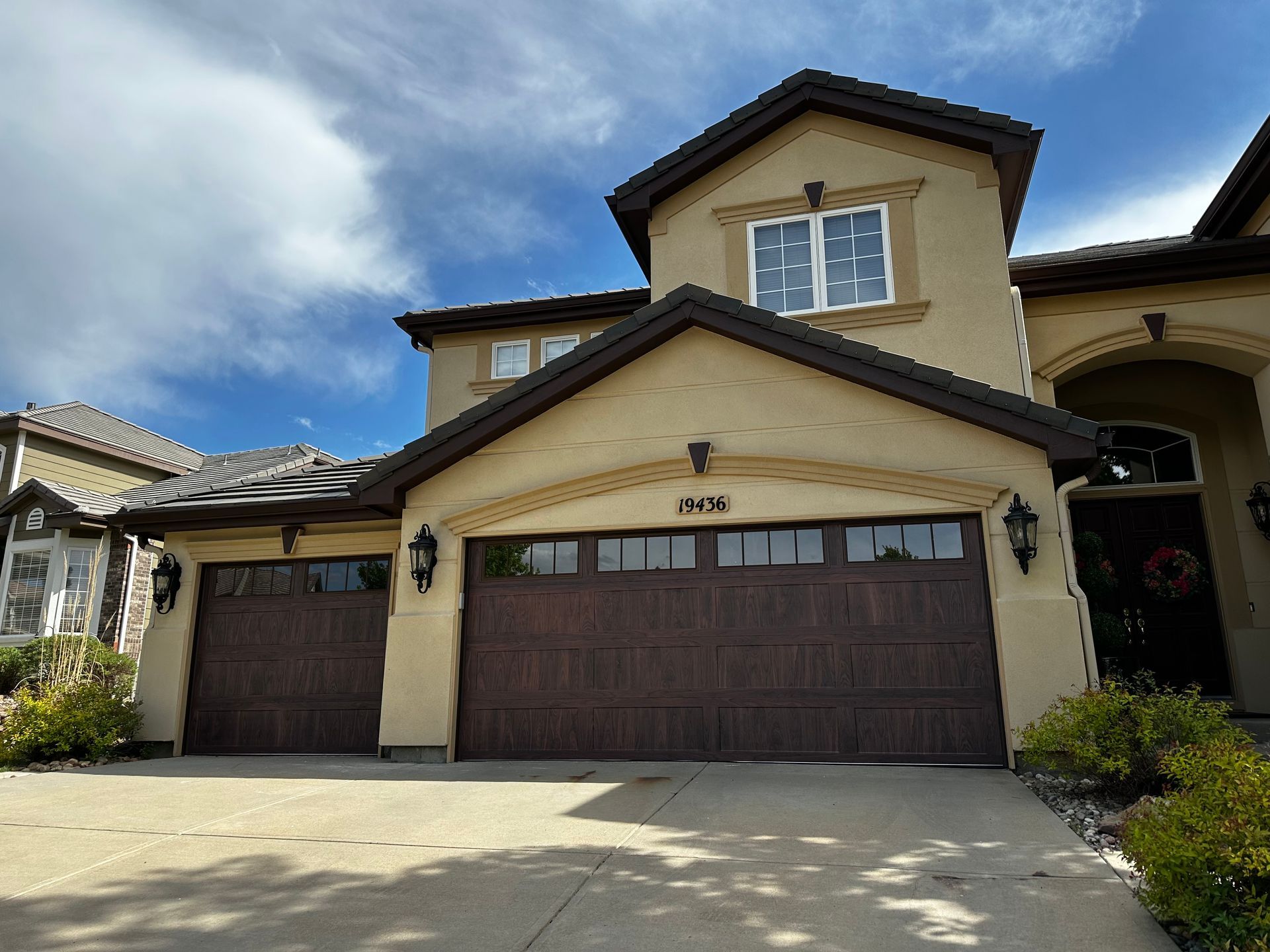 A large house with two garage doors and a driveway