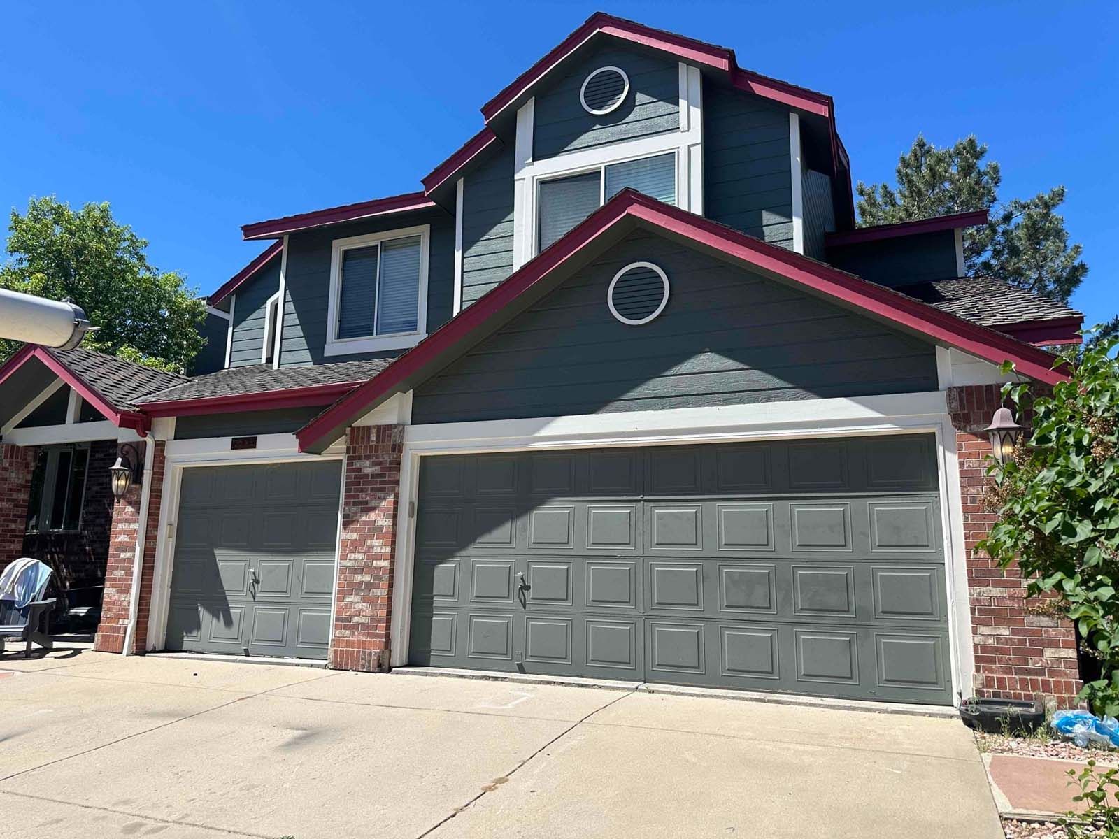 A large house with two garage doors and a red roof