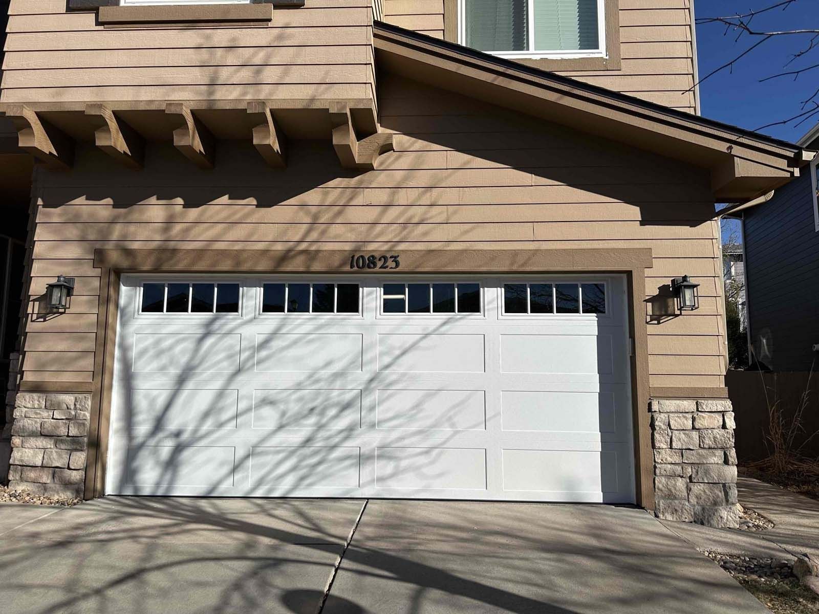 The front of a house with a white garage door