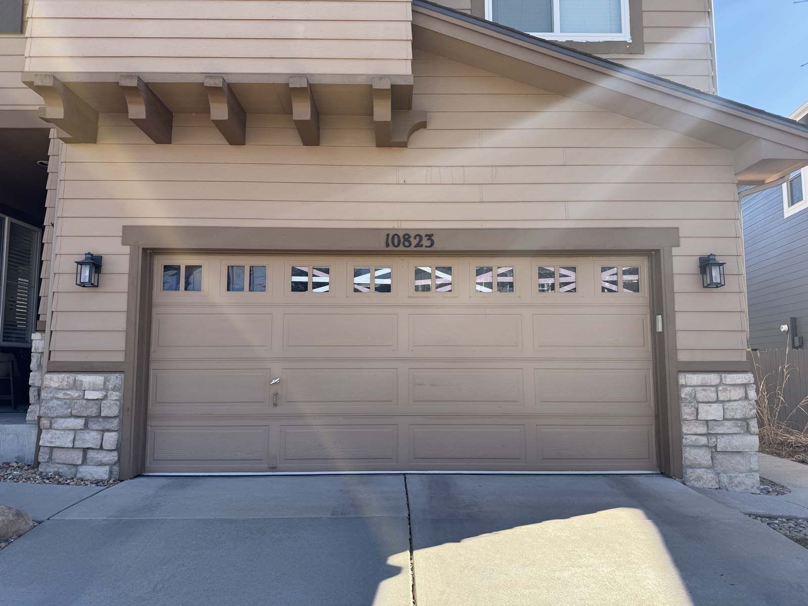 The garage door of a house with the number 10823 on it
