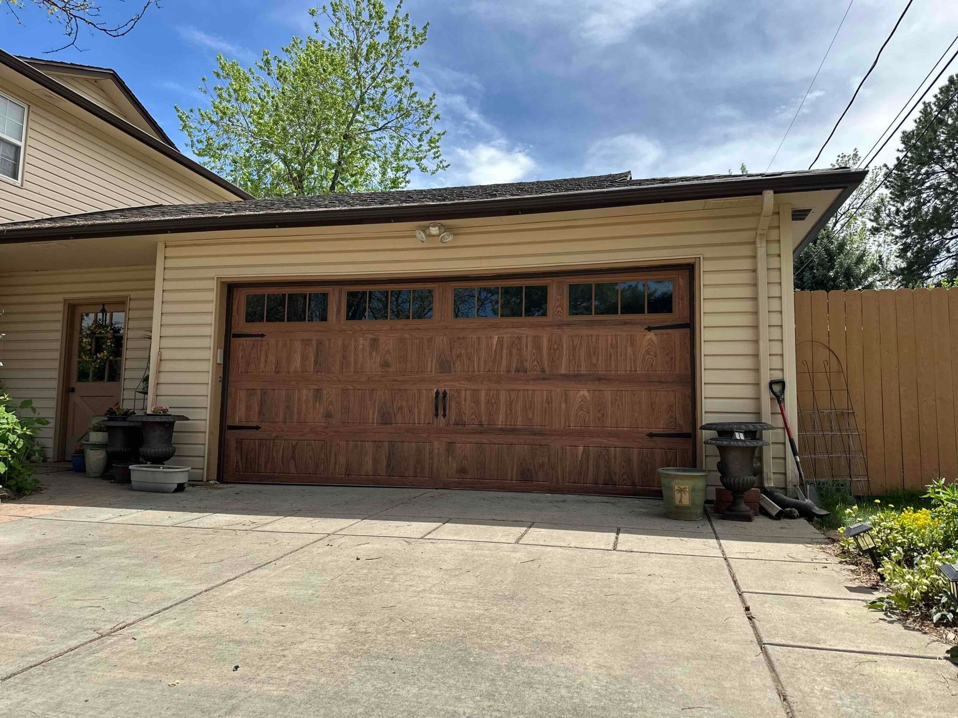 There is a large garage door in the driveway of a house.