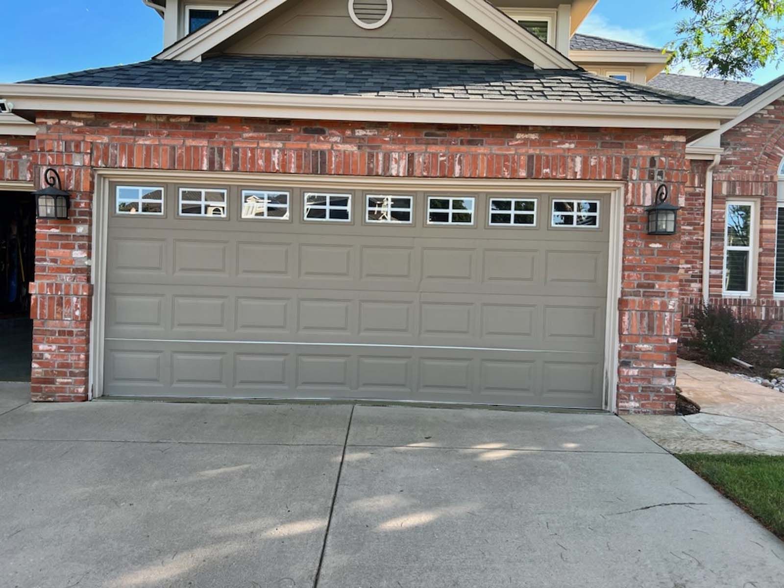 A large brick house with a large garage door.