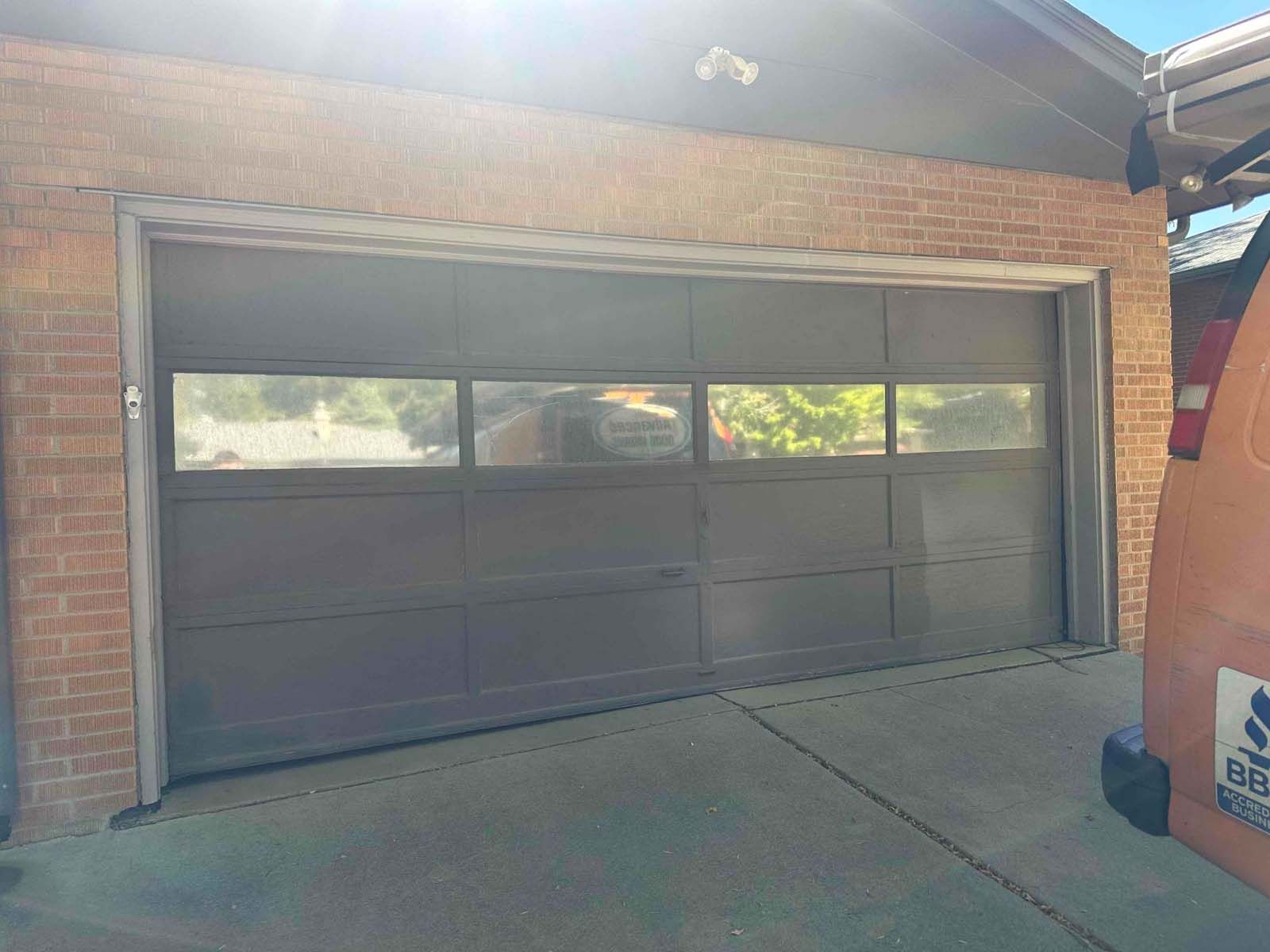 A garage door with a van parked in front of it.