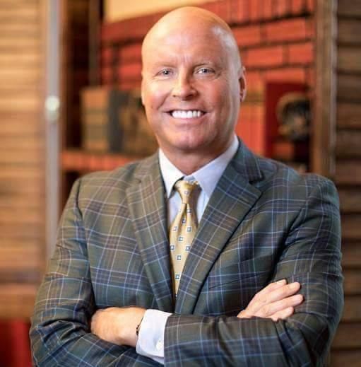 A bald man with a beard wearing a suit and tie