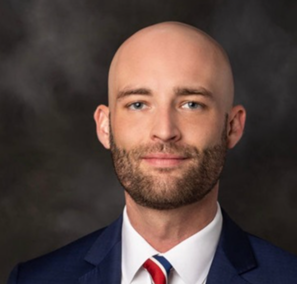 A bald man with a beard wearing a suit and tie