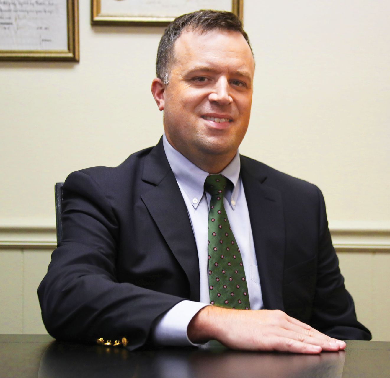A man in a suit and tie is sitting at a desk