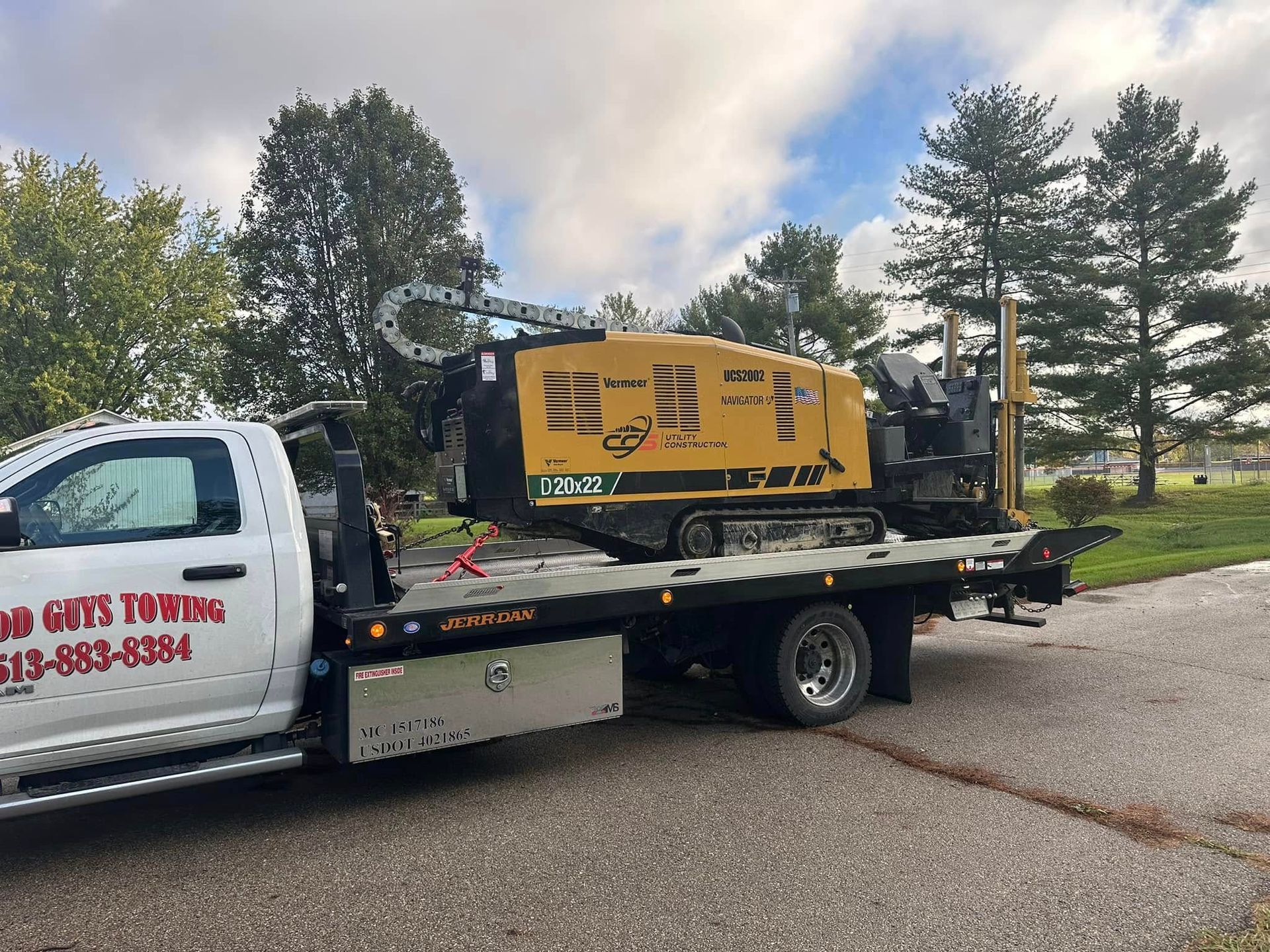 Tow truck carrying a yellow horizontal directional drilling machine.