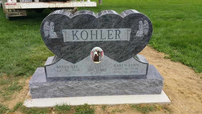 Heart-shaped granite gravestone with “KOHLER” engraved, standing on a grassy lawn.