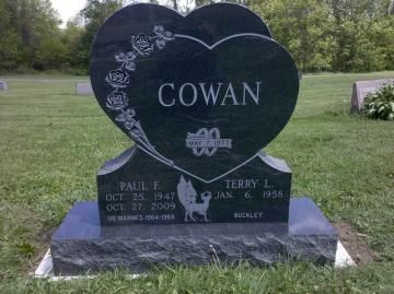 Black heart-shaped memorial stone with the name COWAN in a grassy cemetery