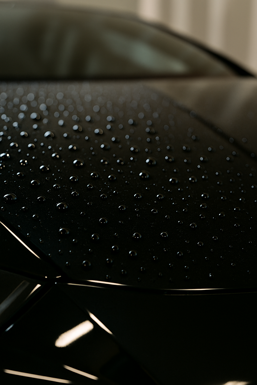 Black car hood with water droplets.