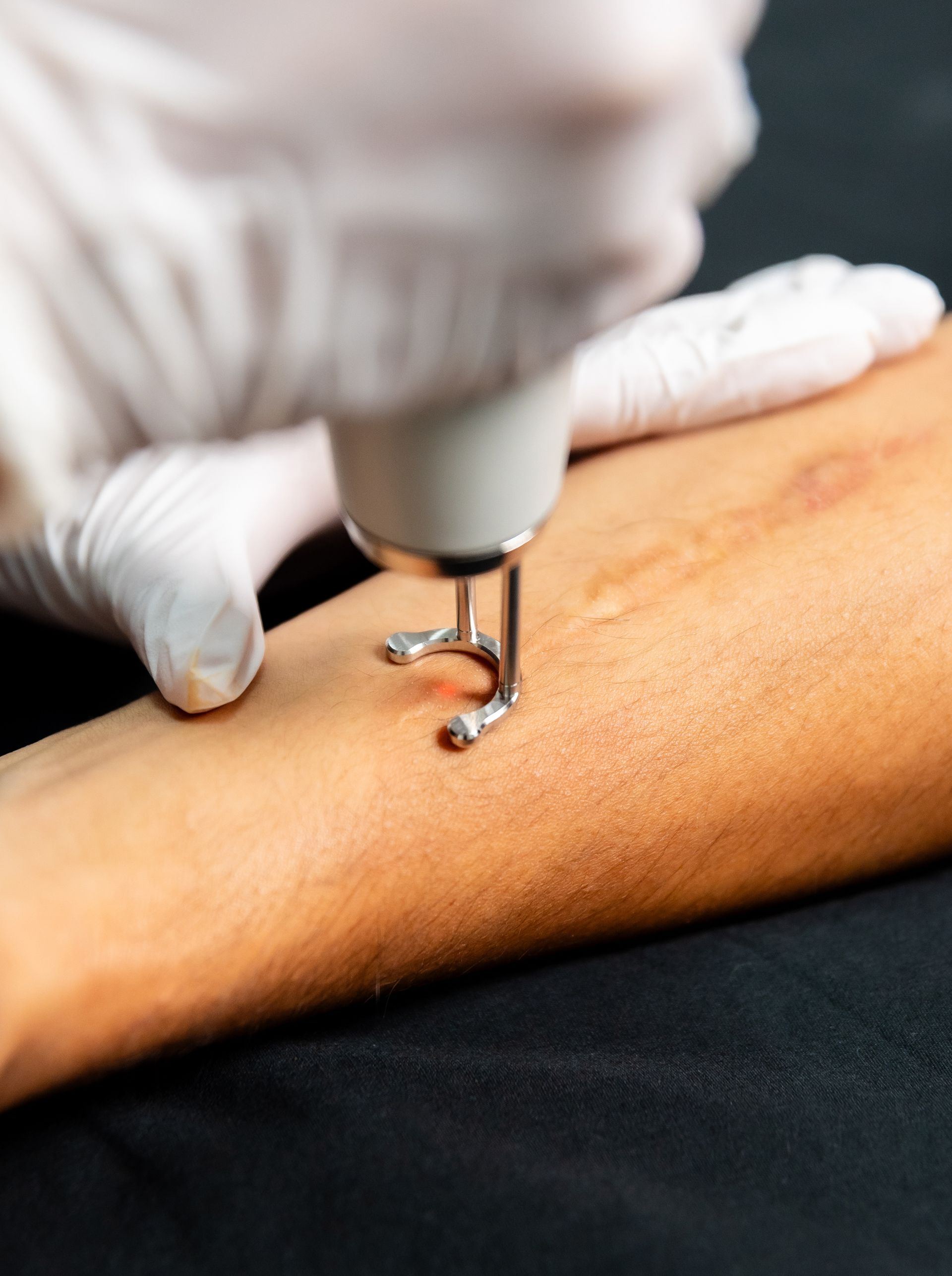Two white and gray handheld medical devices sit on a purple and white machine. 