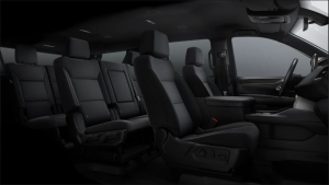 Black interior of a vehicle with two rows of seats.