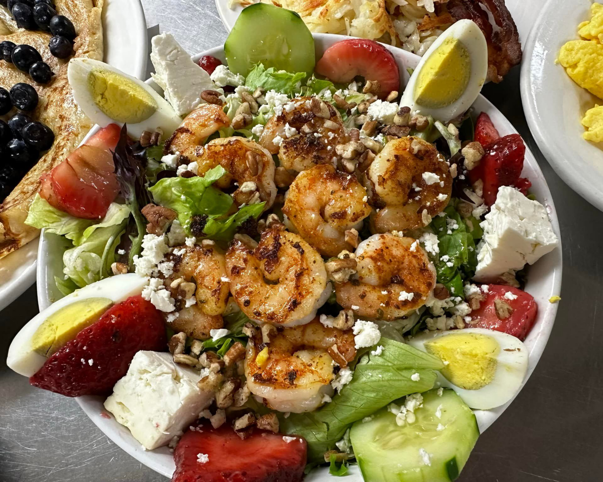 Shrimp salad with strawberries, cucumbers, feta, chopped walnuts, and hard-boiled eggs.