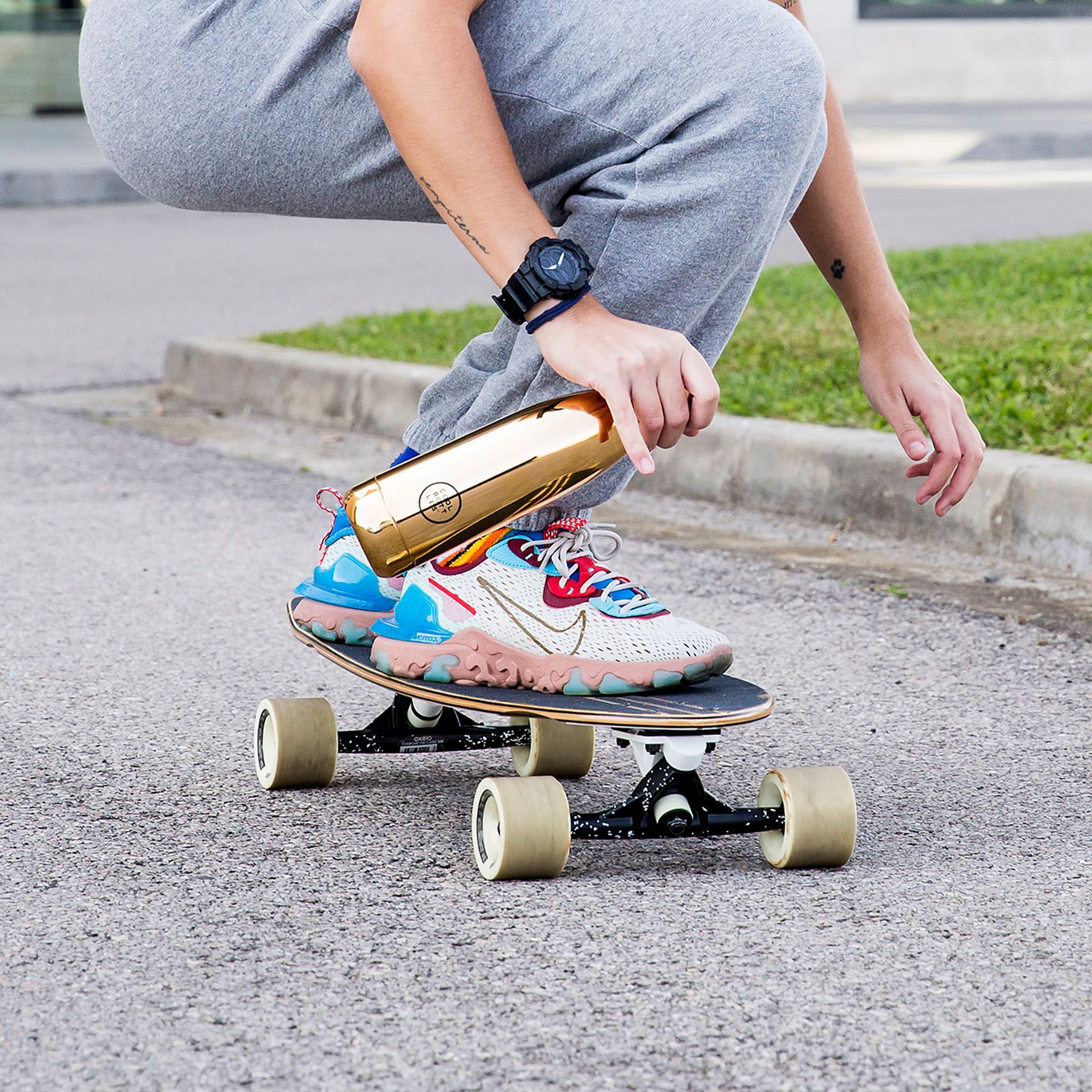 Mulher com garrafa térmica na mão enquanto anda de skate