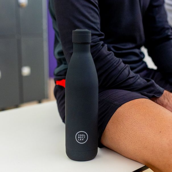Atleta com uma garrafa térmica preta da Cool Bottles no balneário