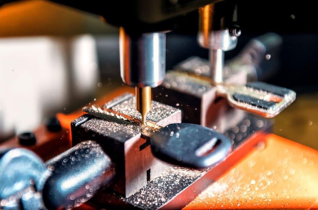Una máquina corta una llave en un trozo de metal.