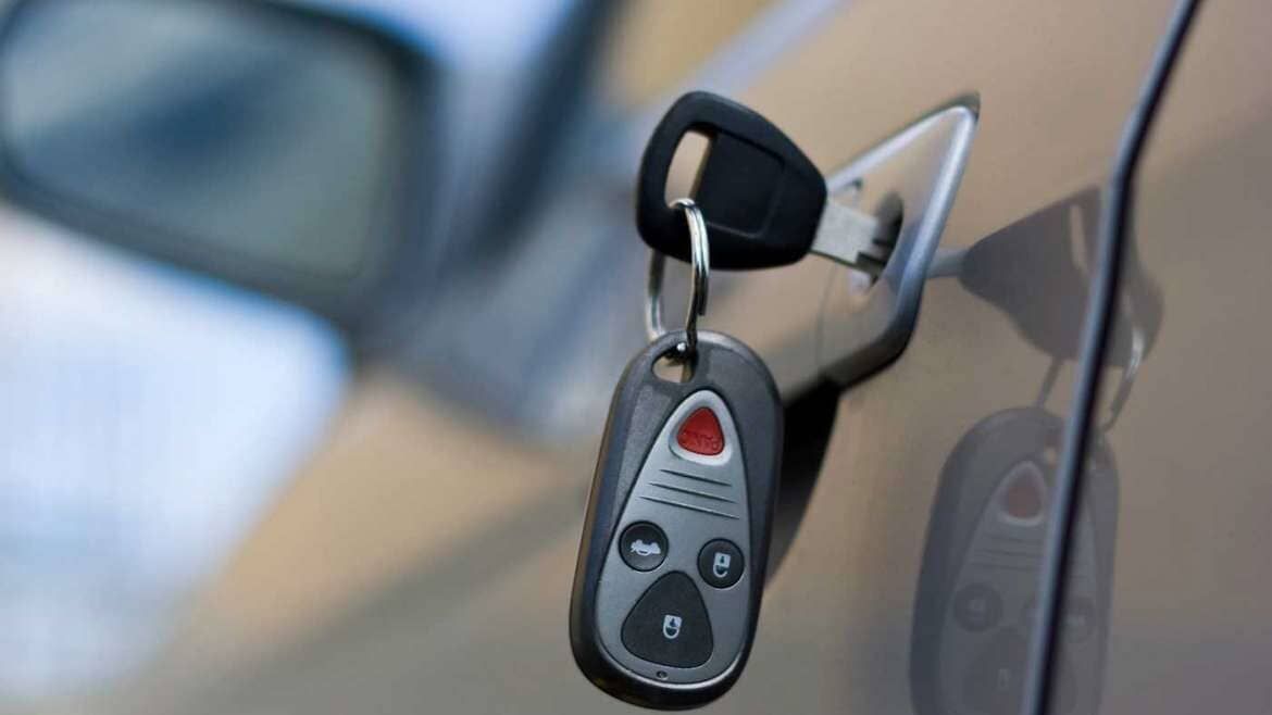 La llave de un auto está colgada en el costado de un auto.