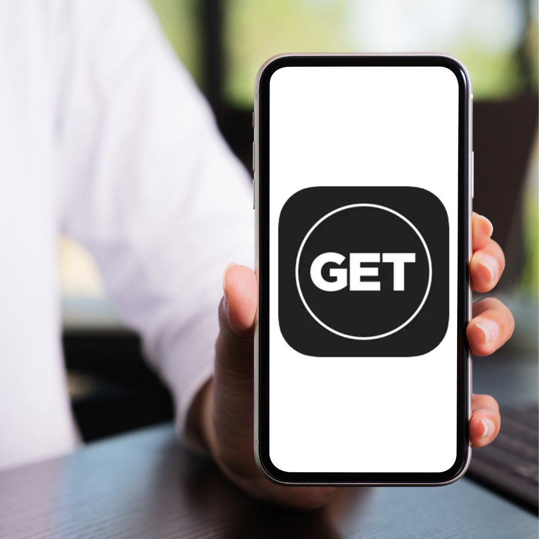 Person holding a phone displaying a black square app icon with the white text 