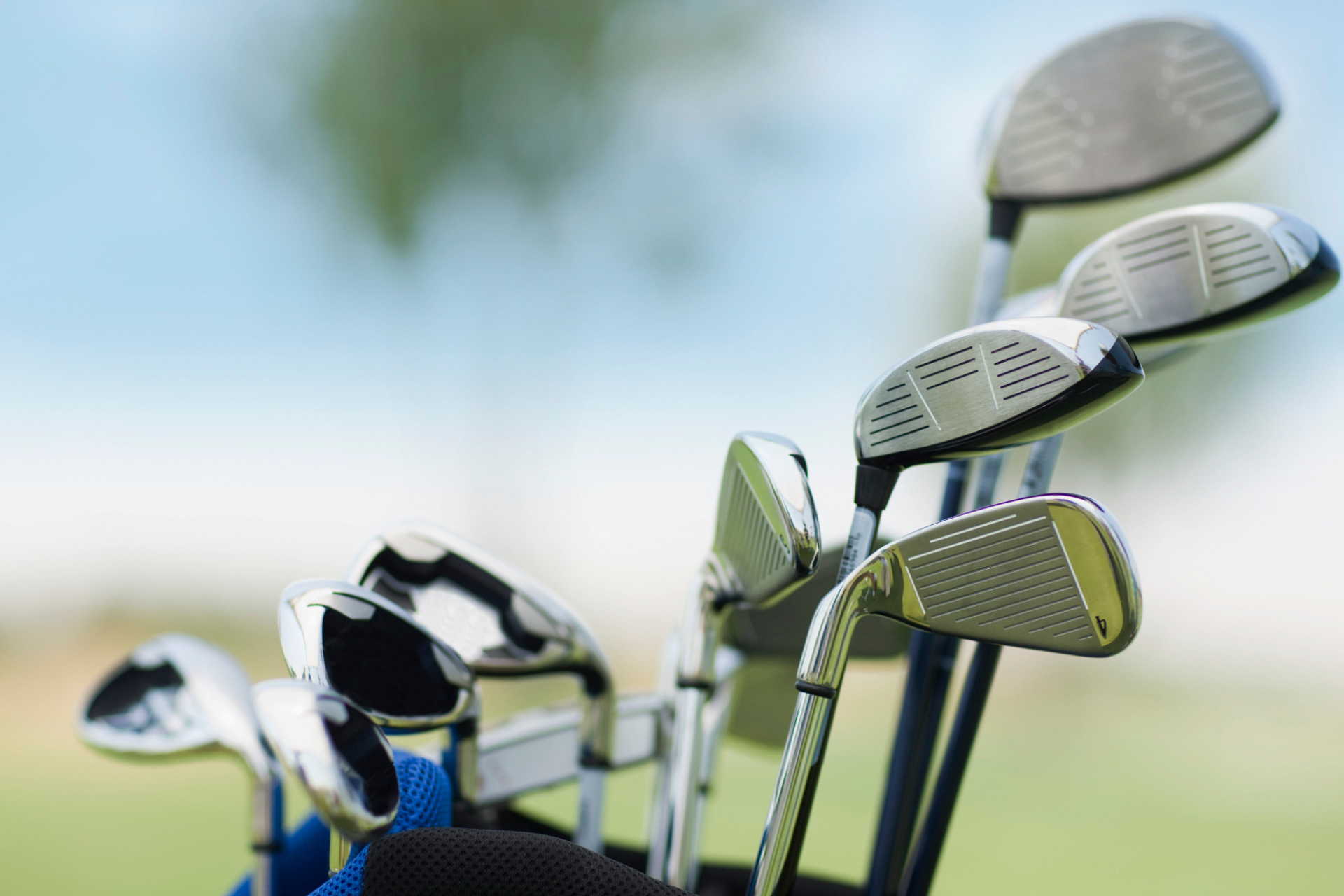 A collection of golf clubs standing upright in a golf bag against a soft, blurred background.