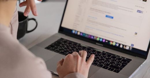 A person is typing on a laptop computer.