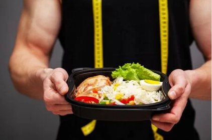 A man is holding a container of food in his hands.