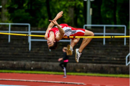 A person is jumping over a bar on a track