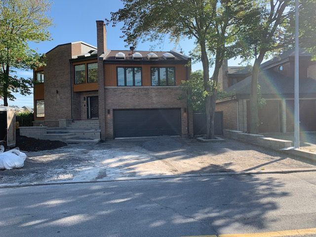 Une grande maison en briques avec une porte de garage noire