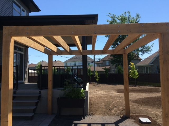 Une pergola en bois se trouve dans l'arrière-cour d'une maison