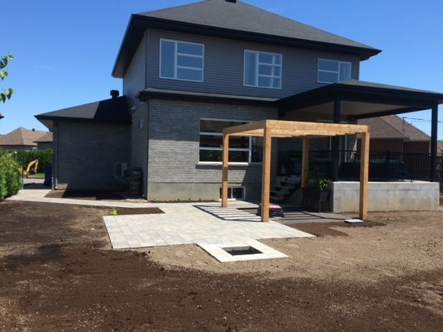 Une maison avec une pergola en bois devant