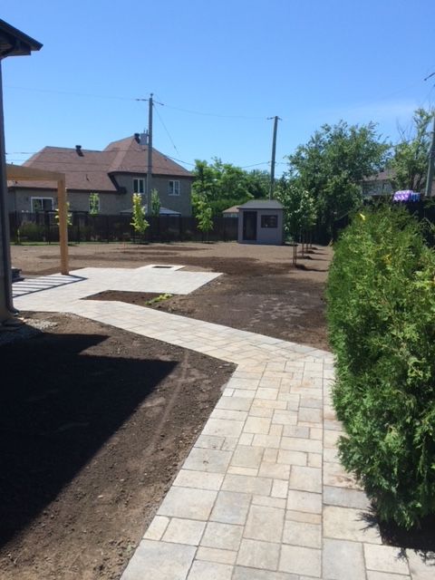 Une allée en briques menant à une maison dans une cour arrière
