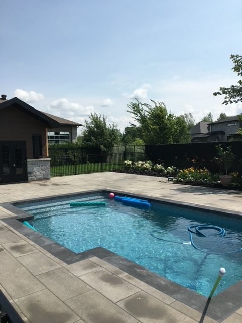 Une grande piscine avec une maison en arrière-plan