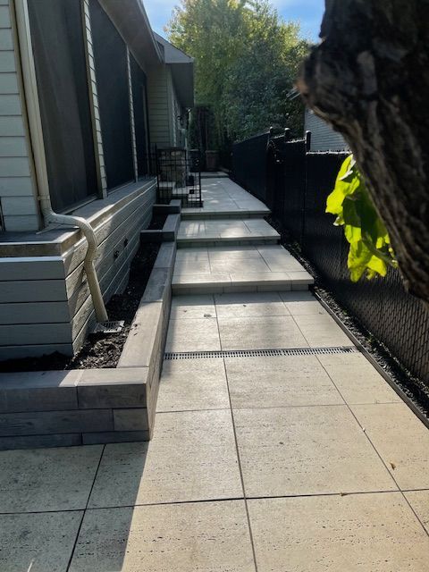 Une allée menant à une maison avec un arbre au premier plan