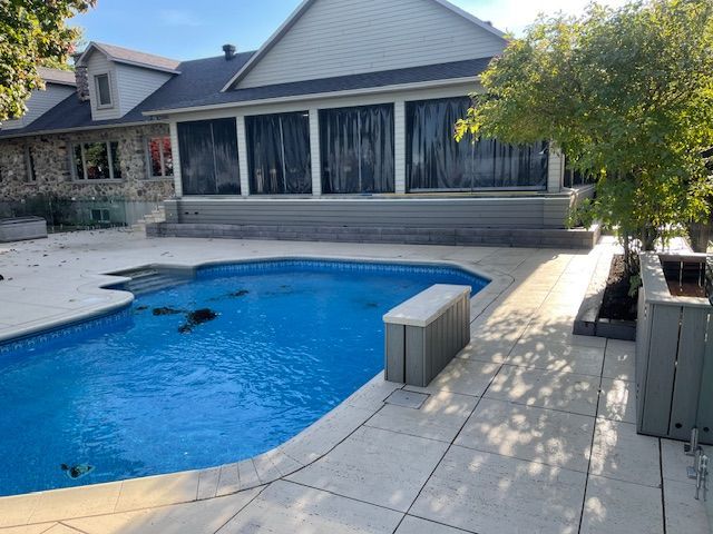 Il y a une grande piscine dans l'arrière-cour d'une maison.