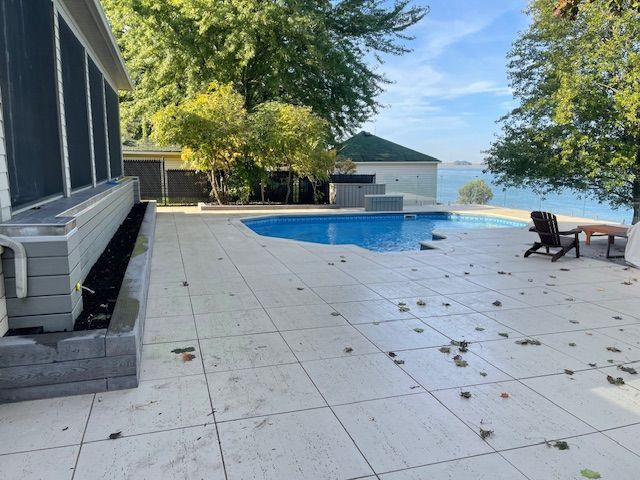 Un patio avec une piscine et une maison en arrière-plan