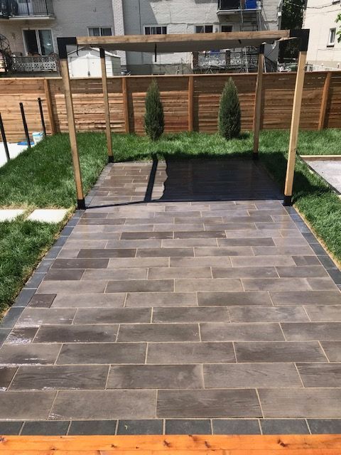 Un patio avec une pergola et une clôture en bois dans une cour arrière.