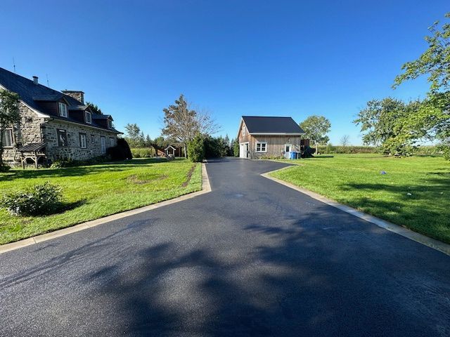 Une allée menant à une maison au milieu d'un champ herbeux.