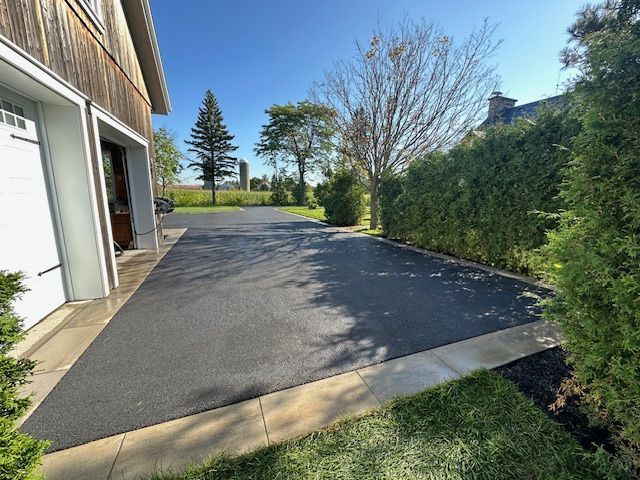 Une allée menant à un garage avec des arbres en arrière-plan