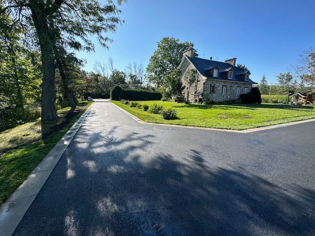 Une maison en pierre se trouve au coin d'une route