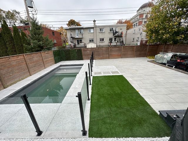 Il y a une piscine dans l'arrière-cour avec une clôture autour.