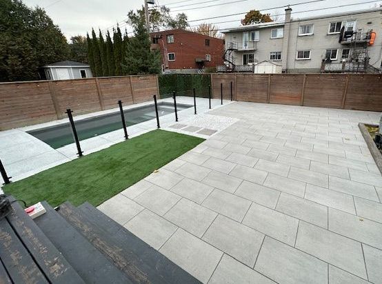 Une cour arrière avec une piscine et une clôture en bois