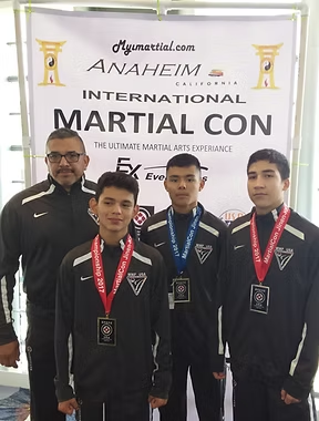 A group of young men standing in front of a banner that says international martial con