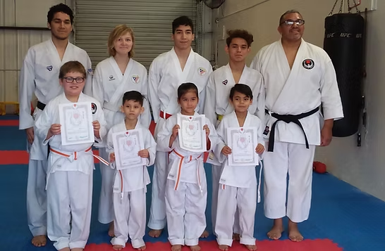 A group of people in karate uniforms are posing for a picture