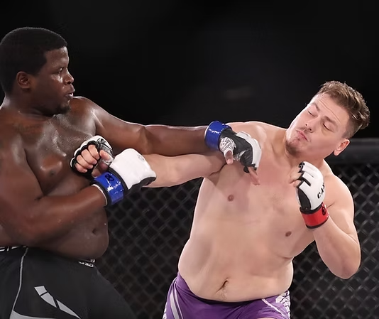 Two men in boxing gloves are fighting in a ring