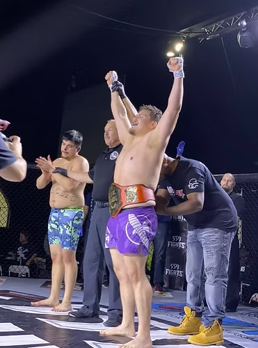 A man is standing on a stage with his arms in the air.