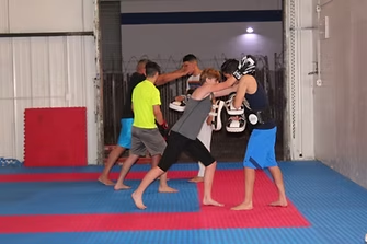 A group of people are practicing martial arts in a gym.