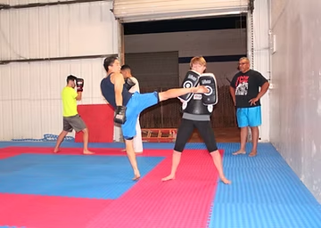 A group of people are practicing martial arts in a gym.